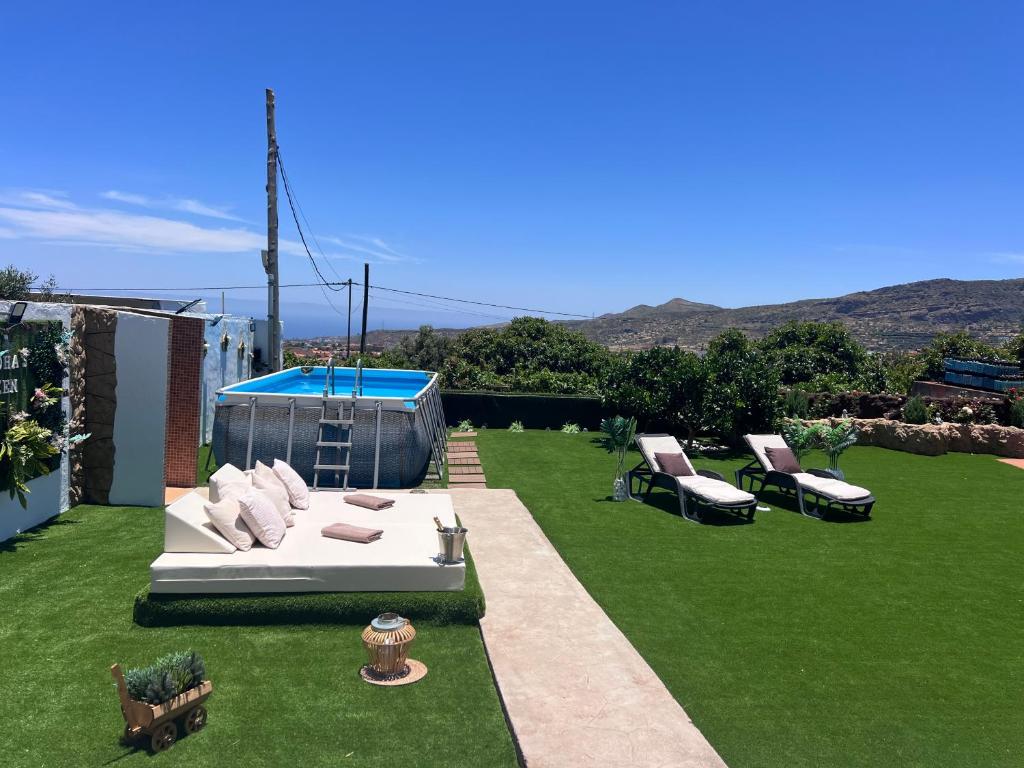 a backyard with a couch and chairs on the grass at Joha's Zen in Islas Canarias