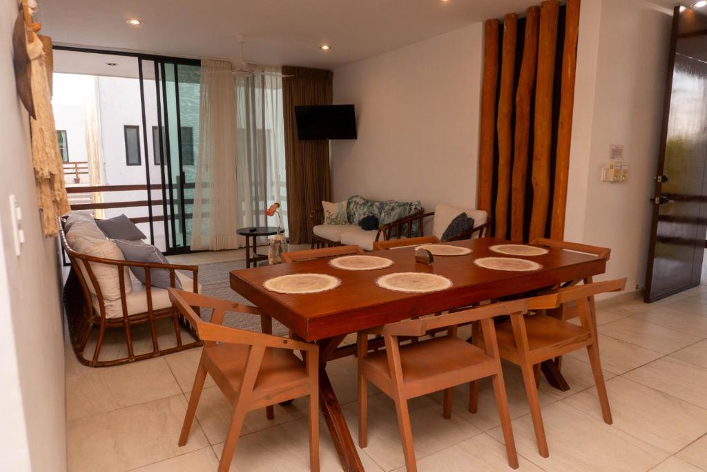 a living room with a wooden table and chairs at Villas Aakal Petirojo in Chicxulub