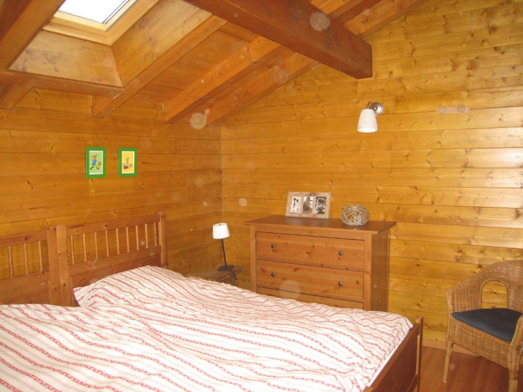 - une chambre avec un lit et un mur en bois dans l'établissement Paljot, à La Chapelle-dʼAbondance