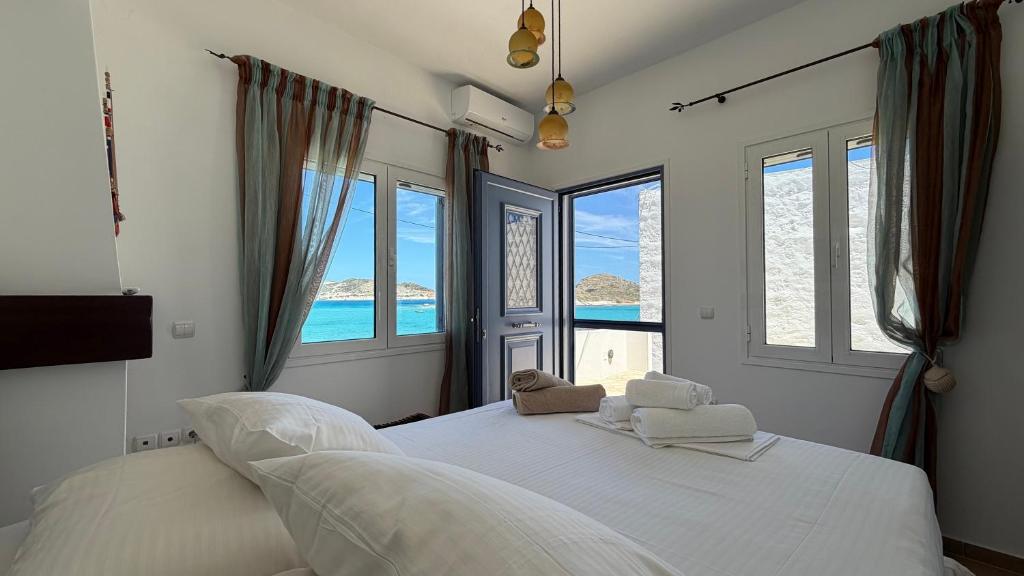 a bedroom with a bed with a view of the ocean at Almira Prassa Beach House Kimolos in Prasonísi
