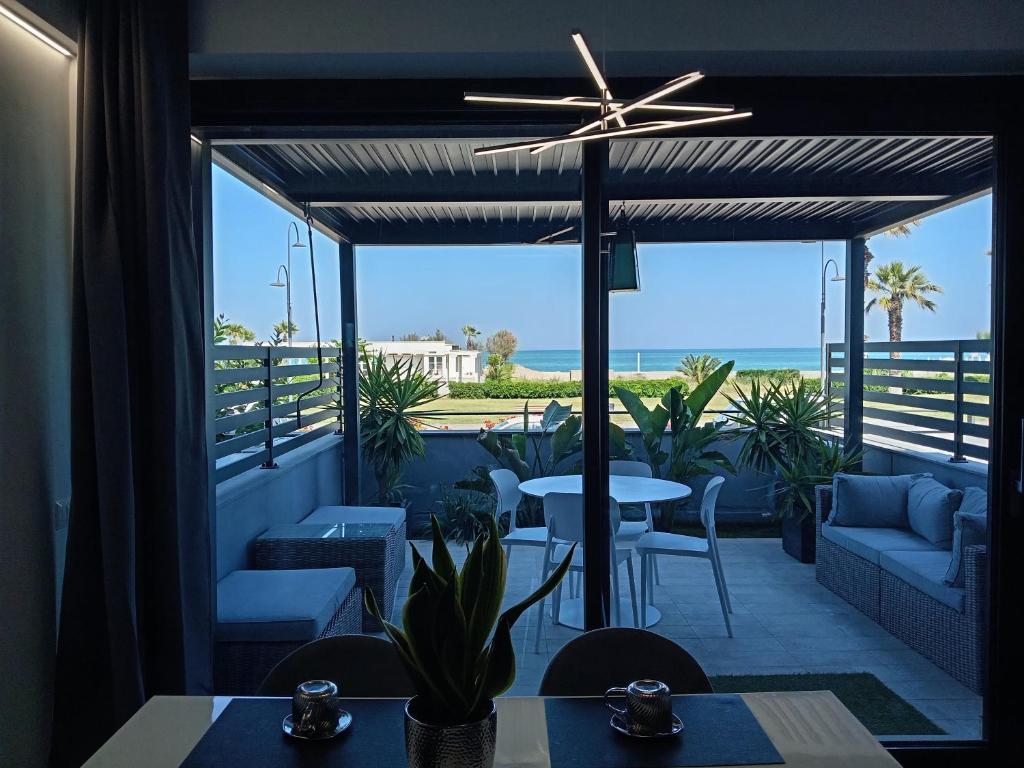 a patio with a table and chairs and a view of the ocean at SUITE CONTI 36 terrazza sul mare 2lettini e ombrellone in Porto SantʼElpidio