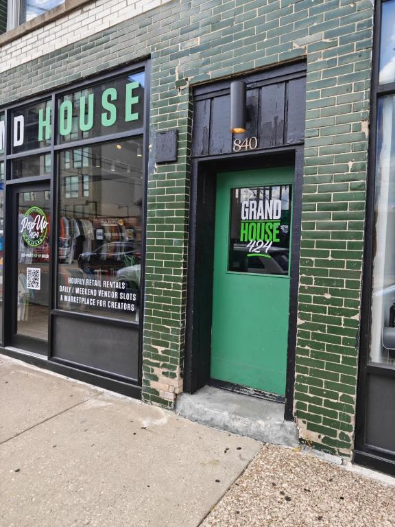 a store front with a green door on a brick building at Grand House in Chicago