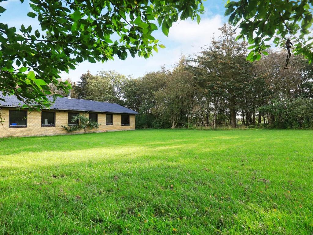 a house in the middle of a large grass field at 6 person holiday home in Nykøbing M in Hesselbjerg