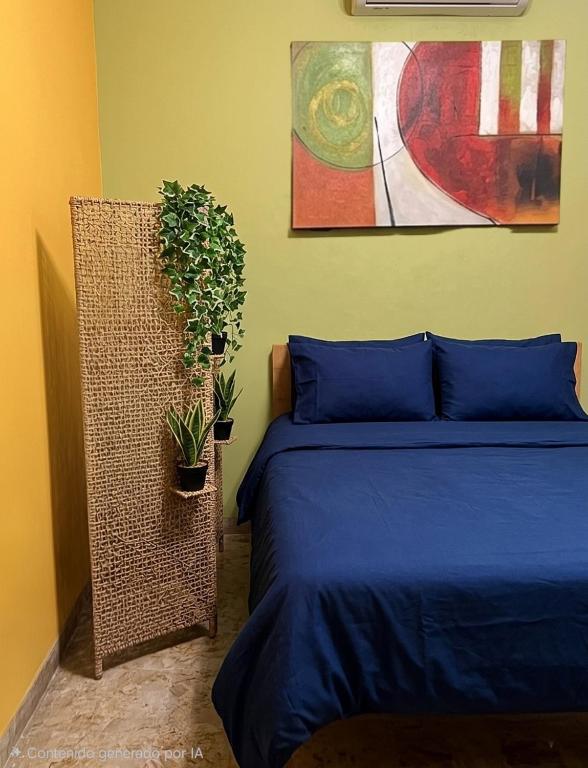 a bedroom with a bed and two potted plants at Posada Doña Alcinda in Catia La Mar