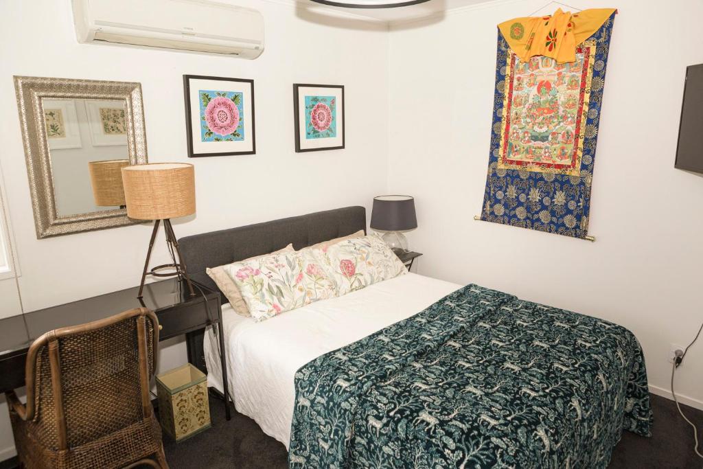 a bedroom with a bed and a mirror at Nyima Tashi Buddhist Centre in Auckland