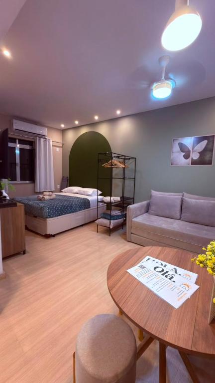 a living room with a bed and a table at Studio no Centro do Rio l Próximo ao Metrô e VLT in Rio de Janeiro