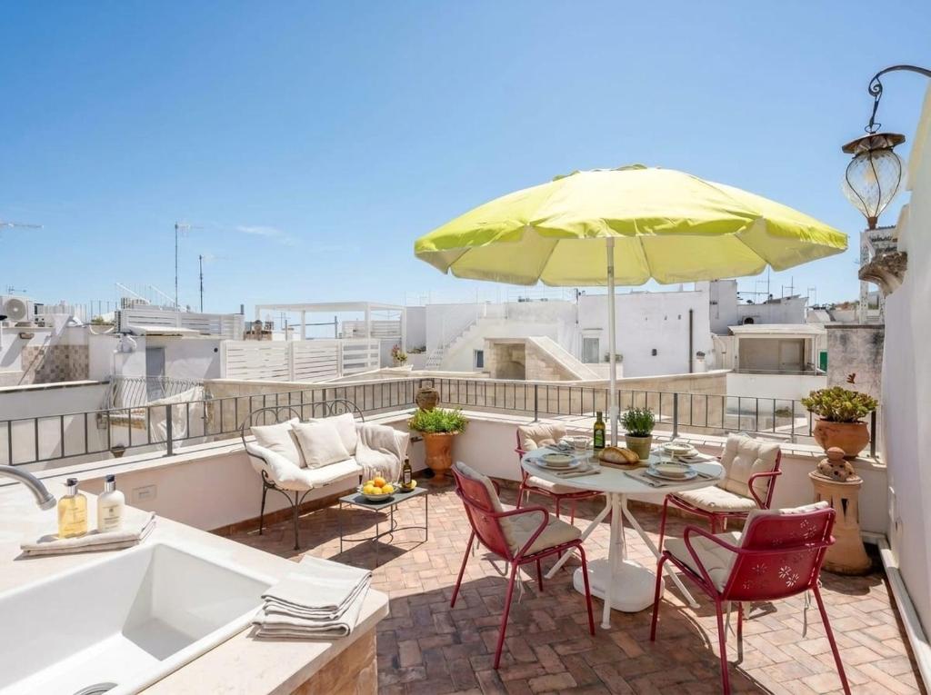 a patio with a table and chairs and an umbrella at Dimora BoxFish - Panorama terrace in Polignano a Mare