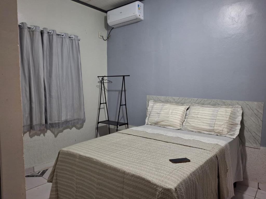 a bedroom with a bed with a white comforter at M&A Hospedagem in Cruzeiro do Sul