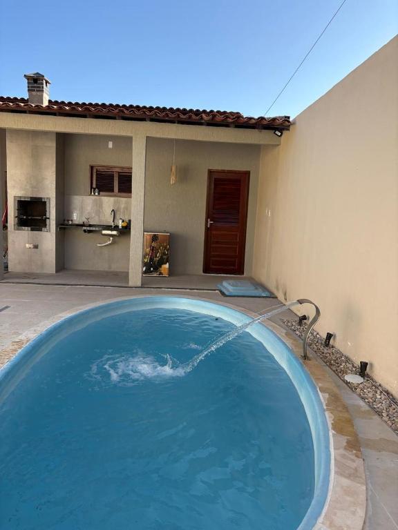 a large blue swimming pool in front of a house at Casa TS Morro Branco in Beberibe
