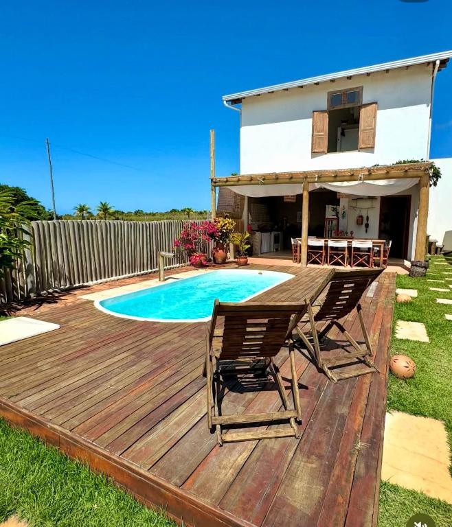 a deck with two chairs and a swimming pool at Casa Mangaba da Praia in Prado