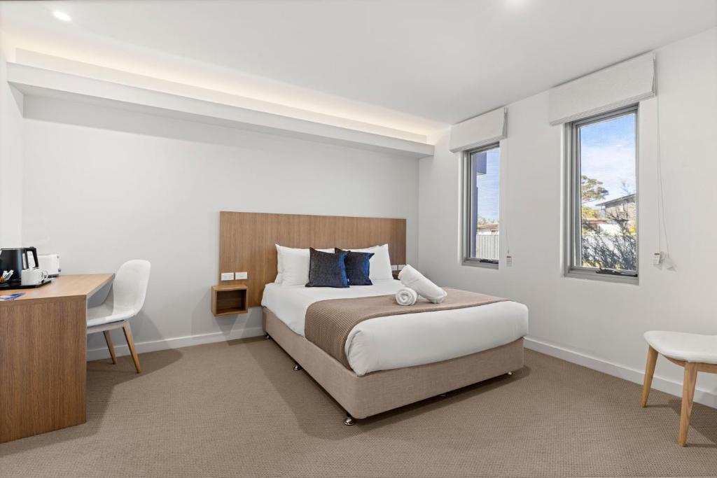 a bedroom with a bed and a desk and window at Modern Queen Studio - 6 Mins to Callala Beach in Callala Beach
