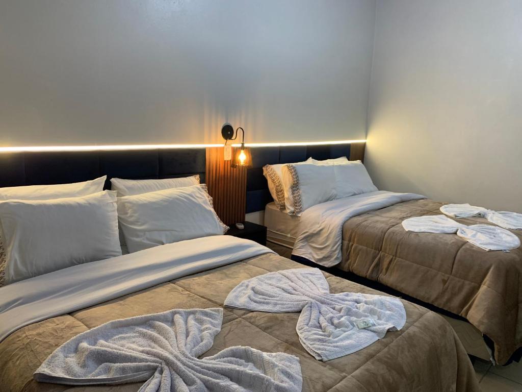 a room with two beds with blankets on them at Pousada HG-102-Suíte in Vila Nova do Sul