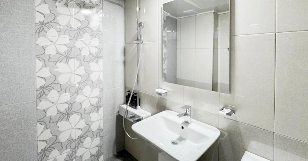 a white bathroom with a sink and a mirror at Hotel Barley Field Seoknam in Incheon
