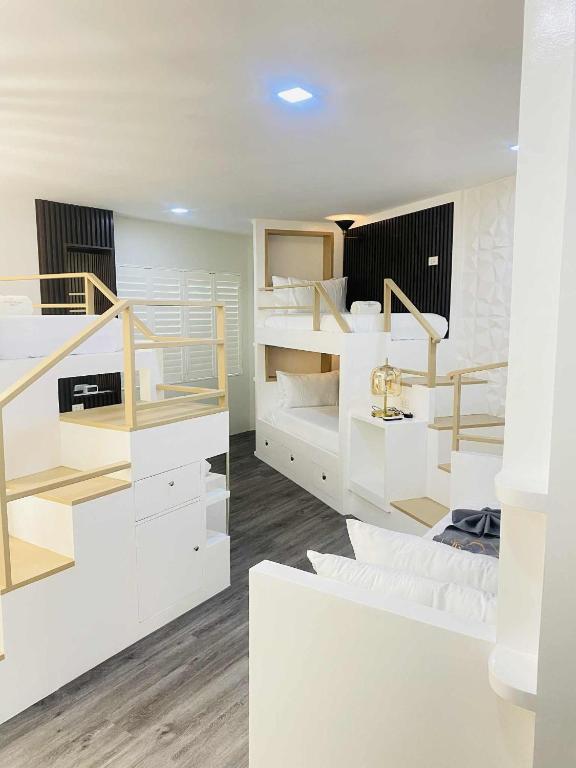 a room with white bunk beds and wooden floors at Grospe Resort Boracay in Boracay