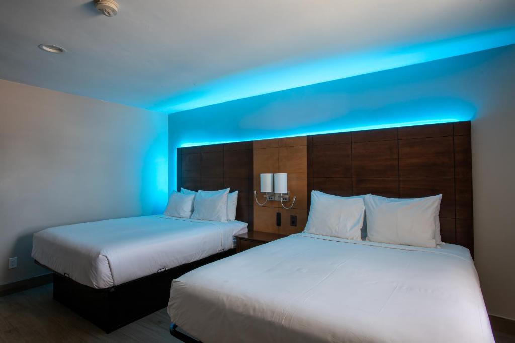 two beds in a hotel room with a blue light at The Inn On 66 Flagstaff in Flagstaff