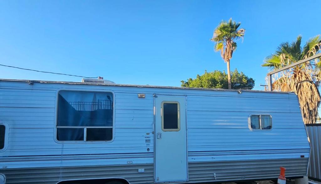 a blue trailer parked in front of a palm tree at Casa Rodante Tony 2 in San Felipe