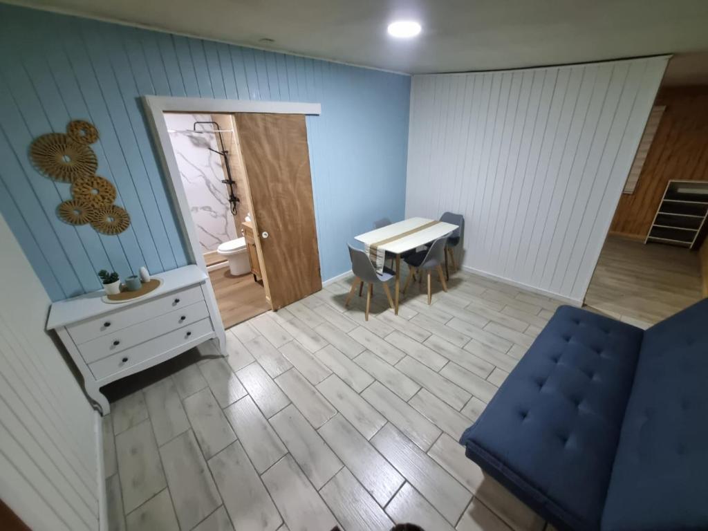 a room with a table and a blue wall at Departamento interior en el centro de llanquihue in Llanquihue