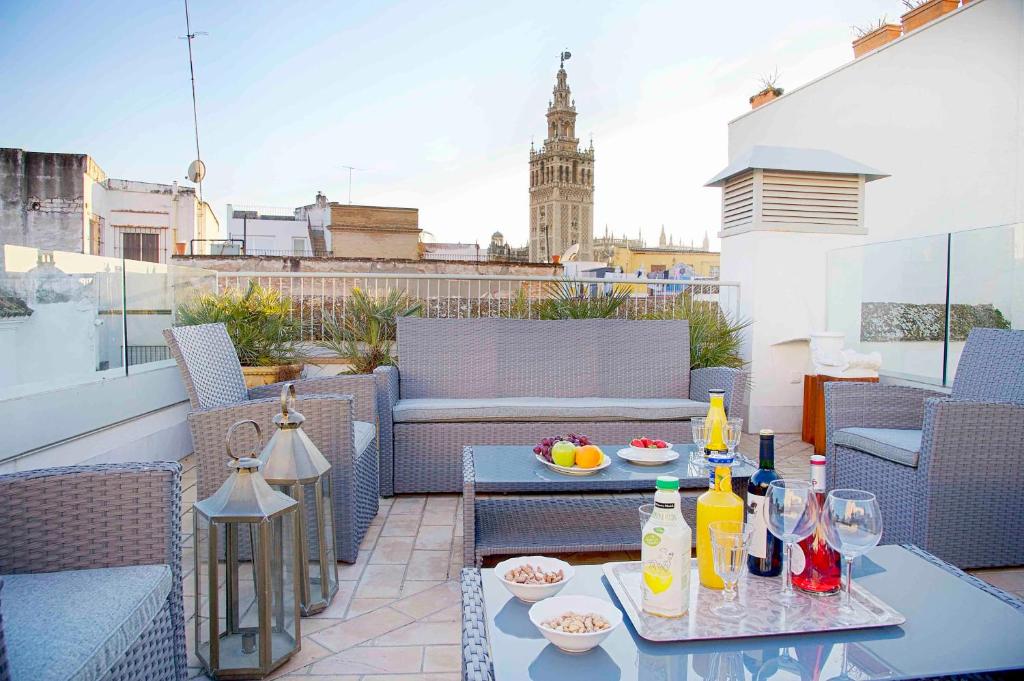 a patio with a table and drinks on a balcony at Overland Suites Catedral in Seville
