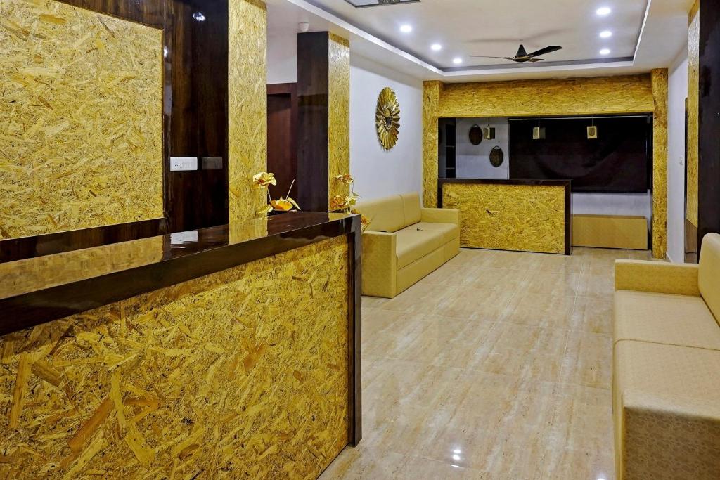 a hotel room with a lobby with a couch and a bed at Collection O Gauri Shree Hotel in Bhopal