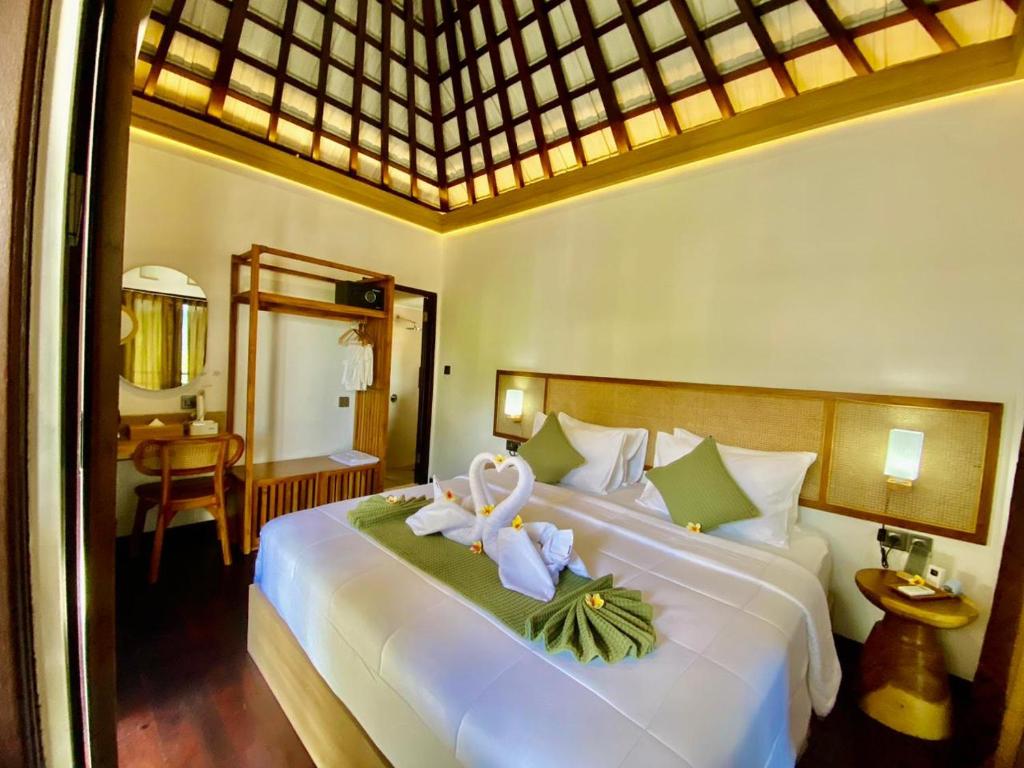 a bedroom with a large white bed with flowers on it at PARAWIYA Villa in Munduk