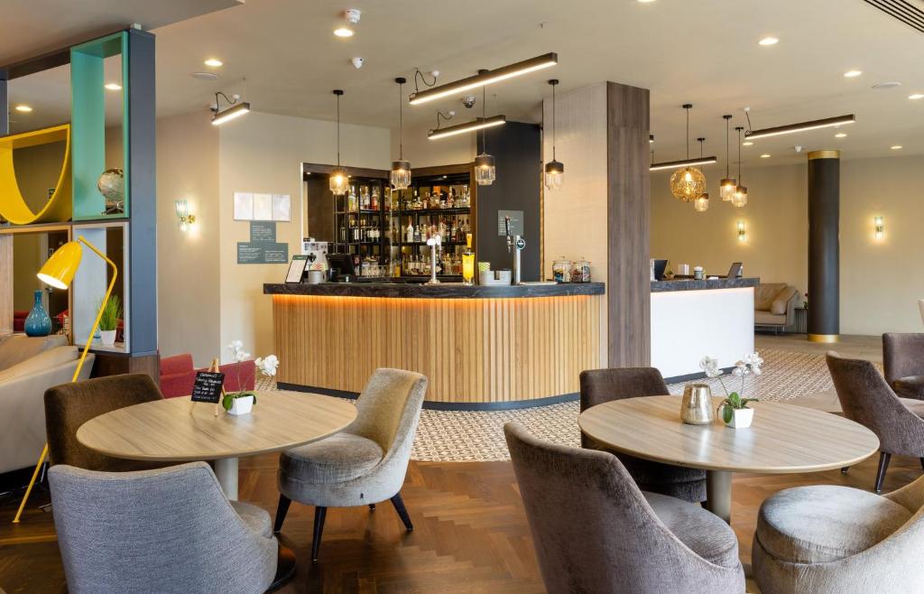 a restaurant with two tables and chairs and a bar at Holiday Inn York City Centre by IHG in York