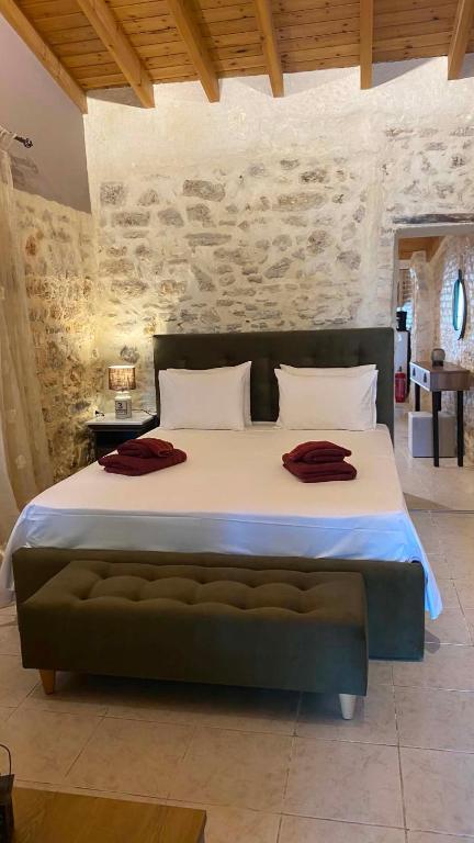 a large bed in a room with a stone wall at CASA THEOTOKI in Anemómylos