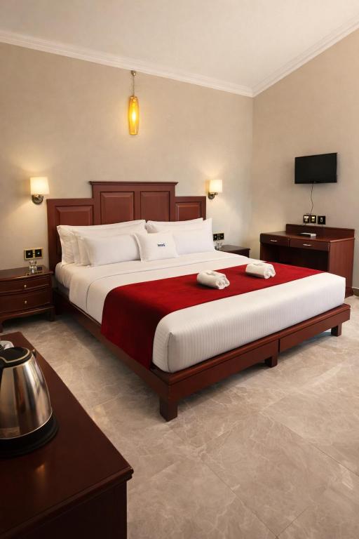 a bedroom with a large bed with a red blanket at Misty D Silver in Munnar