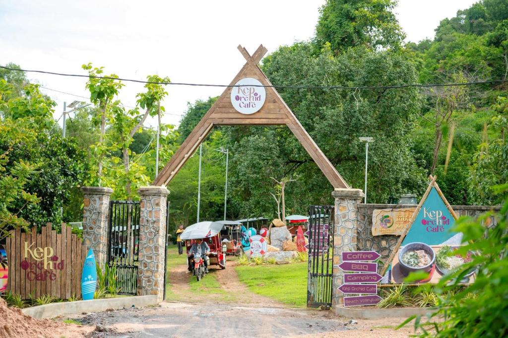 a gate with a clock on top of it at Kep Orchid Cafe in Phumĭ Dâmnăk Châng'aeur