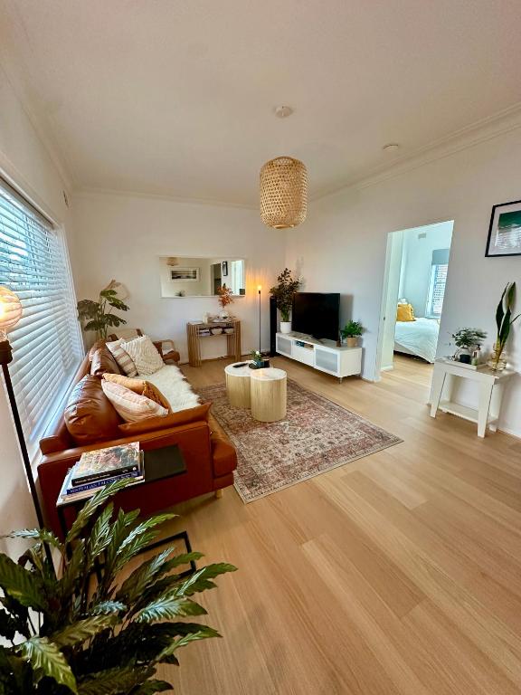 a living room with a couch and a television at Cosy and calm unit in Cronulla in Cronulla
