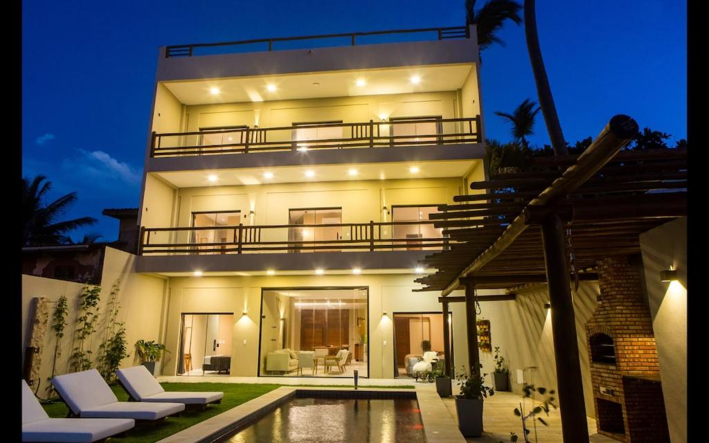 a large house with a swimming pool in front of it at Dona Chica Wellness Center in Taíba
