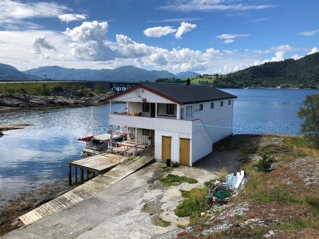 a house on a dock on a body of water at Skjevlingsnes sjøhus in Tingvoll