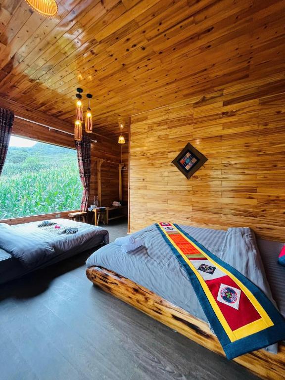 a bedroom with two beds and a wooden wall at TaVan Eco Home in Tả Van