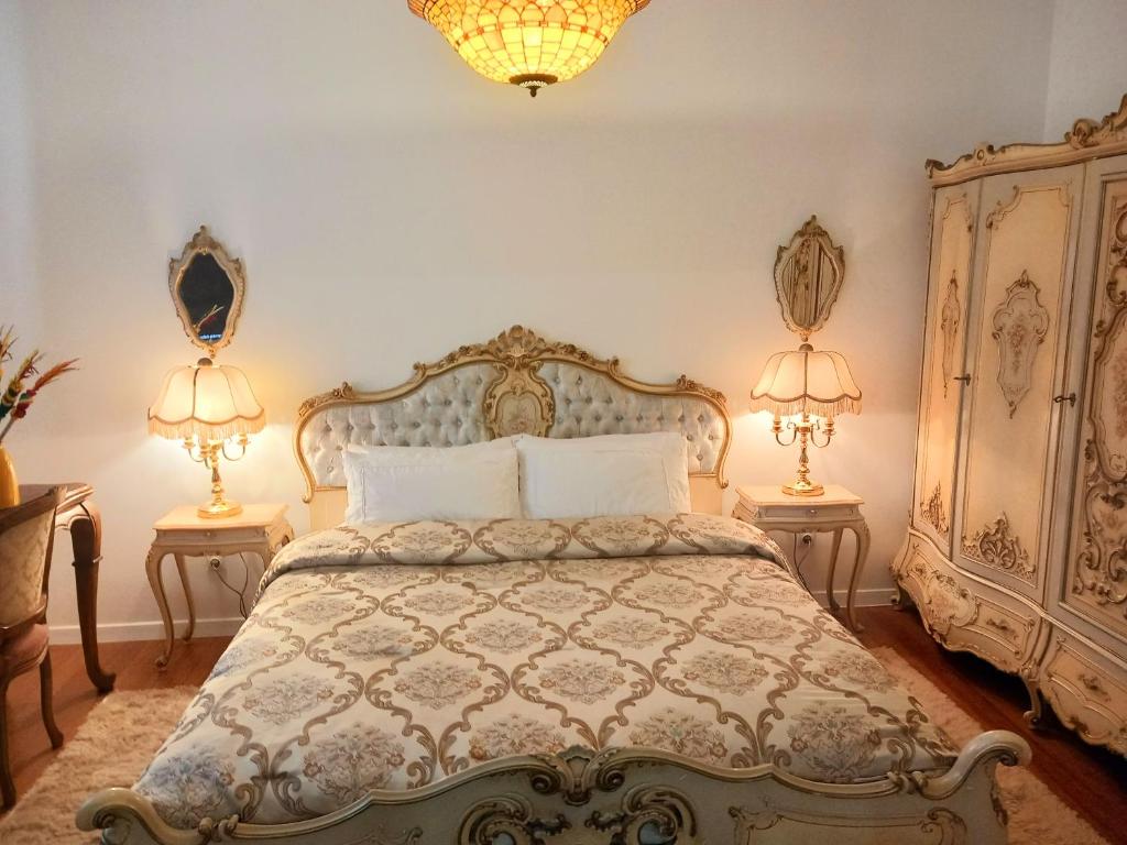 a bedroom with a bed with two lamps on two tables at Bed and Breakfast in Old Town in Naujoji Akmenė