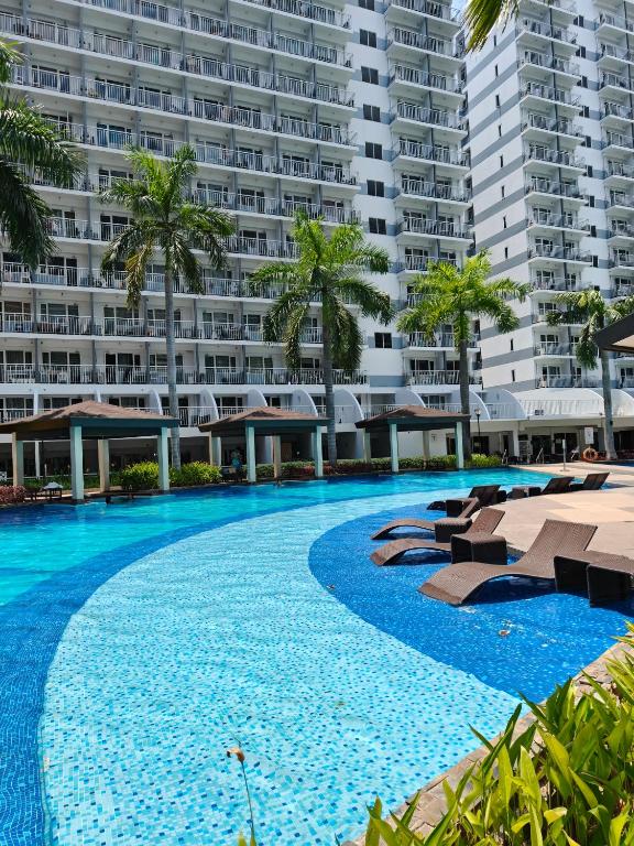 a large swimming pool in front of a large apartment building at MOA shell residences - JOSH in Manila