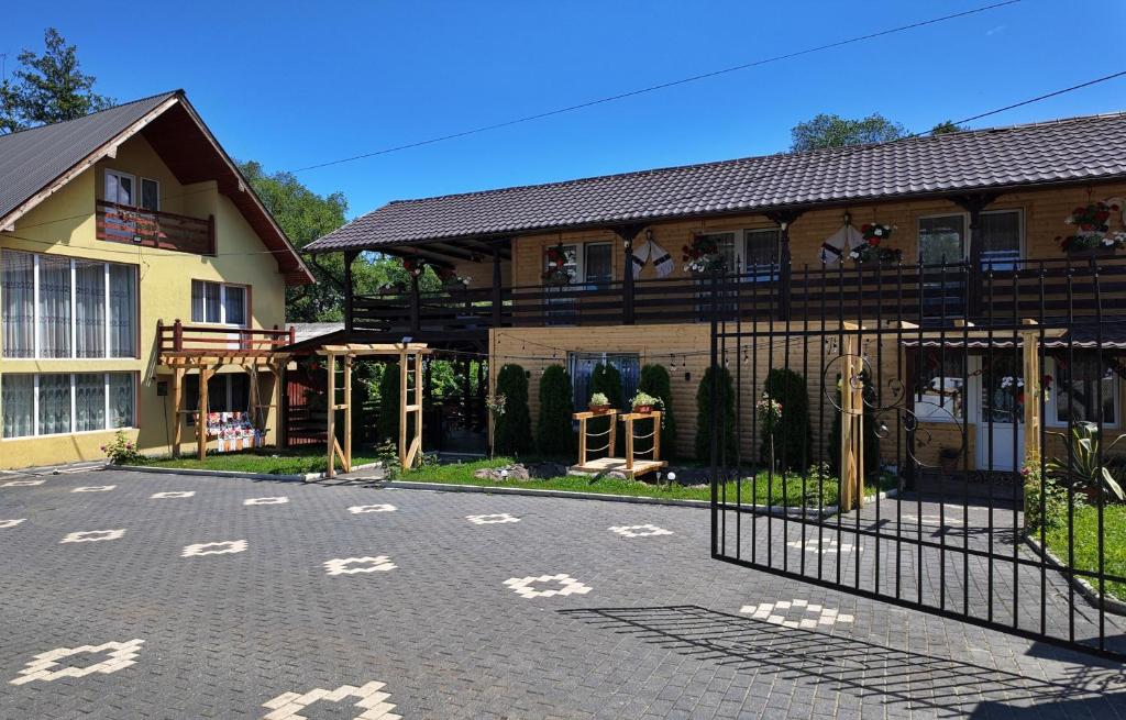 a building with a gate in front of a house at Casa Grigor in Călineşti