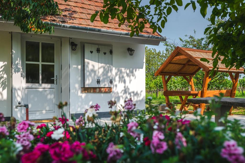 a white house with flowers in front of it at Bleicher Borbirtok in Balatonkeresztúr