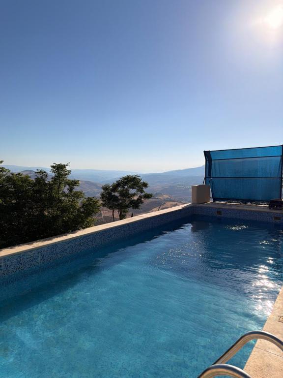 a swimming pool with a view of the mountains at Luxury Mountain Chalet with Private Pool Lionden Jerash in Jerash