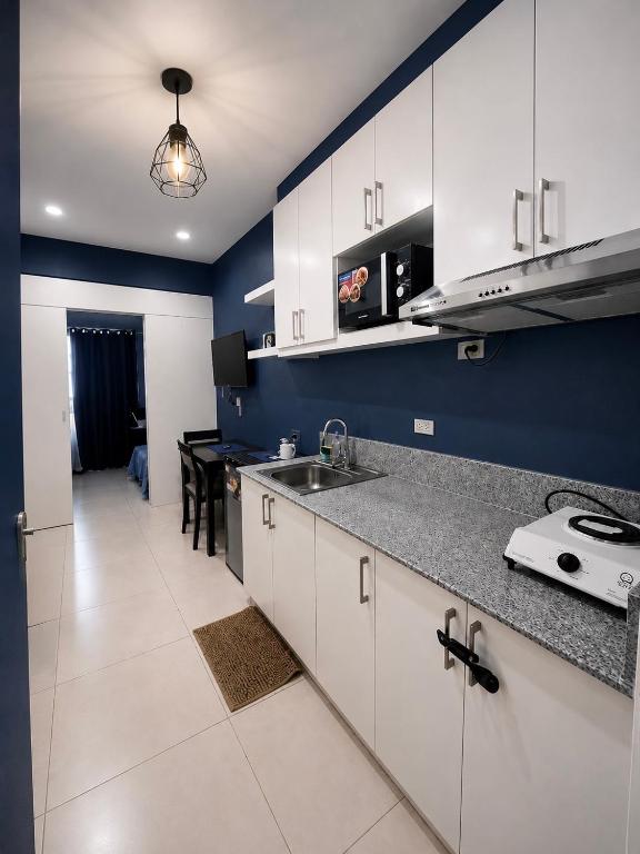 a kitchen with white cabinets and a counter top at Dan's Cool Suites Tagaytay in Tagaytay
