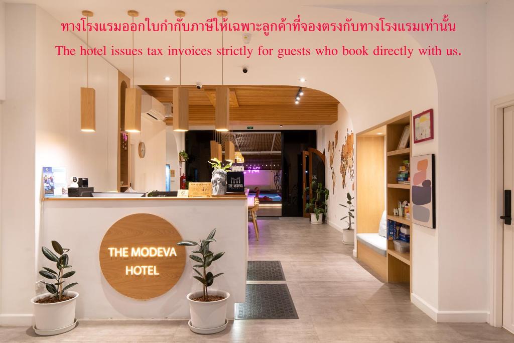 a lobby of a hotel with a counter and plants at The Modeva Hotel in Kanchanaburi City