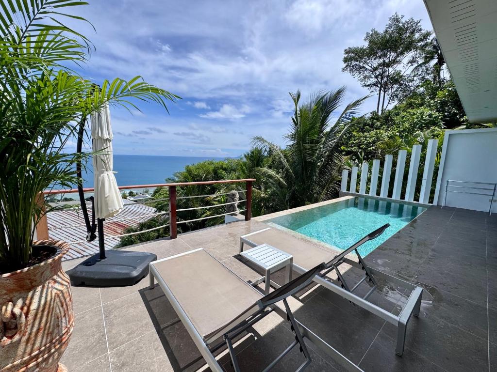 a patio with a pool and chairs and the ocean at LOLISEA Luxe view villas in Salad Beach
