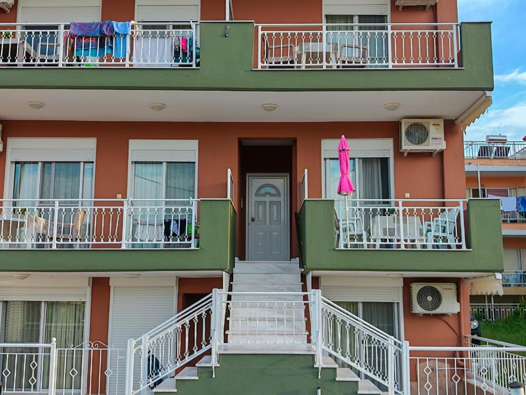 a building with balconies and a door and stairs at Argiro studios in Flogita
