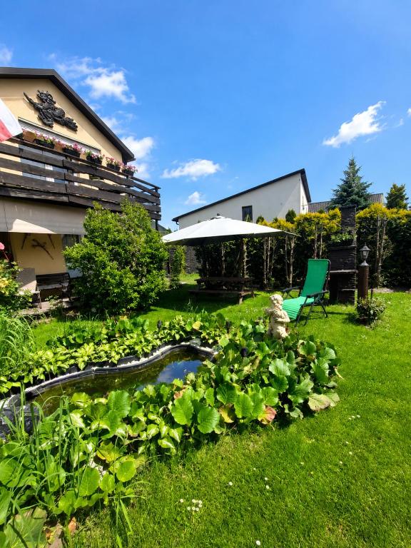 a garden with a pond in the grass at Agroturystyka Hogata in Wąchock