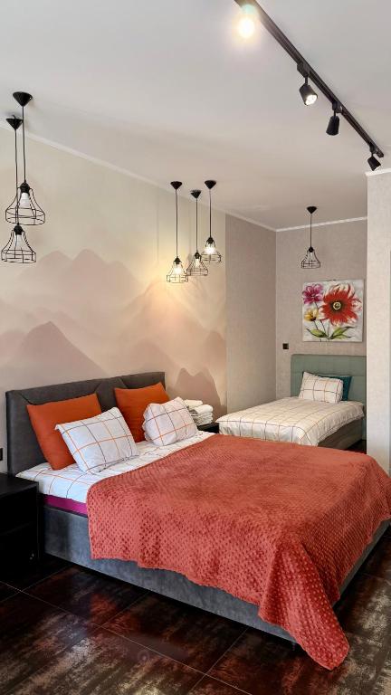 a bedroom with two beds with red and white sheets at Chayka Home Hotel in Chayky
