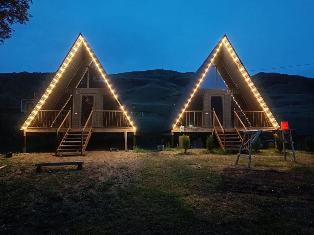 a house with lights on the front of it at UYA A-farme in Saty
