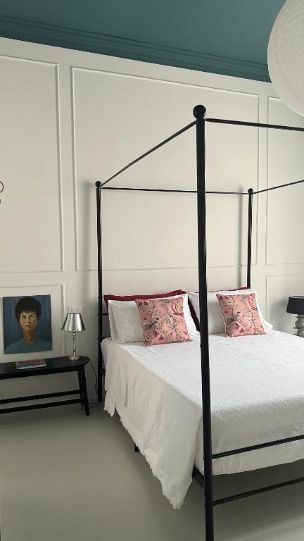 a bedroom with a black canopy bed with pink pillows at Casa Margo in Campobasso