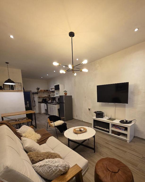 ein Wohnzimmer mit Sofa und Flachbildfernseher in der Unterkunft GARÍ Loft in Chihuahua