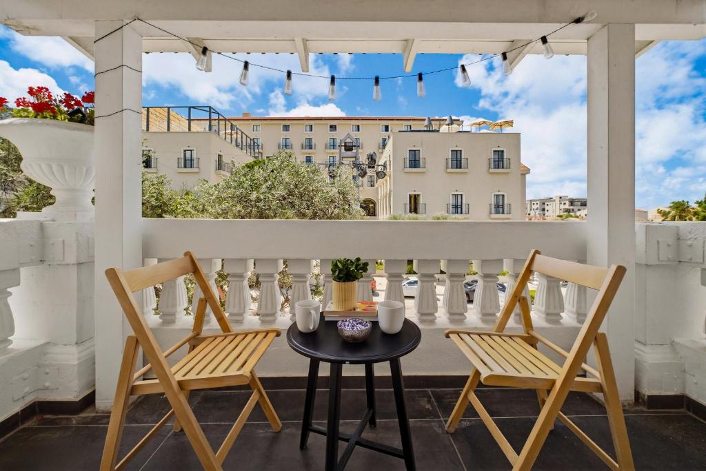 a patio with two chairs and a table on a balcony at City Port Hotel by Sea N Rent in Haifa