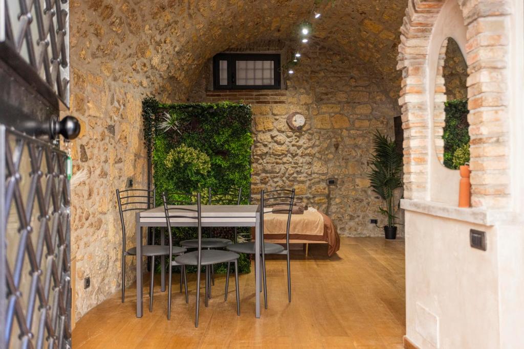 a table and chairs in a room with a bed at Il Butto - Loft Etrusco in Tarquinia
