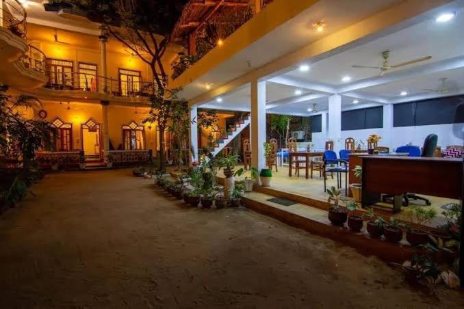 a large building with a courtyard with a table and chairs at Golden Breeze Arugambay in Arugam Bay