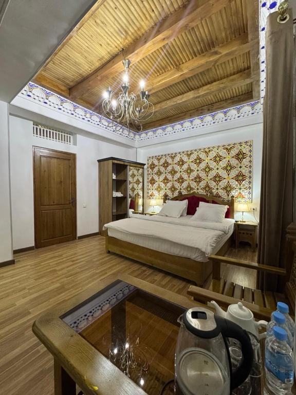 a bedroom with a bed and a table in a room at Central Asia in Bukhara